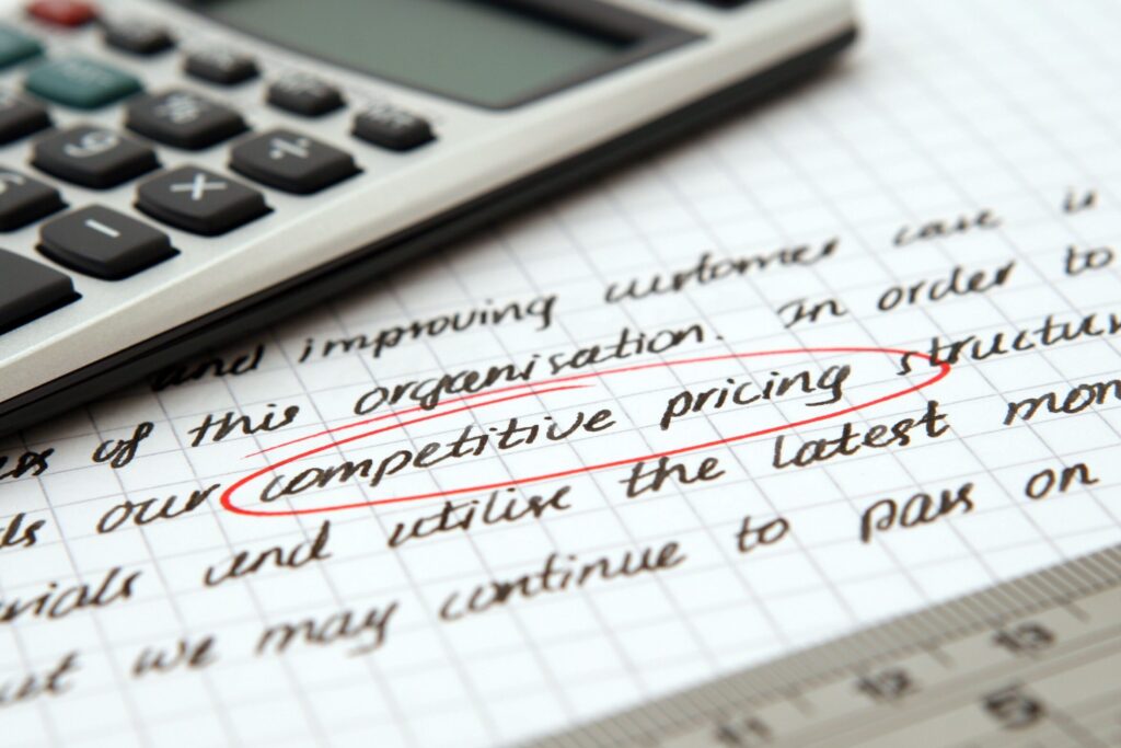 Focused image of handwritten business notes with calculator emphasizing pricing strategy.